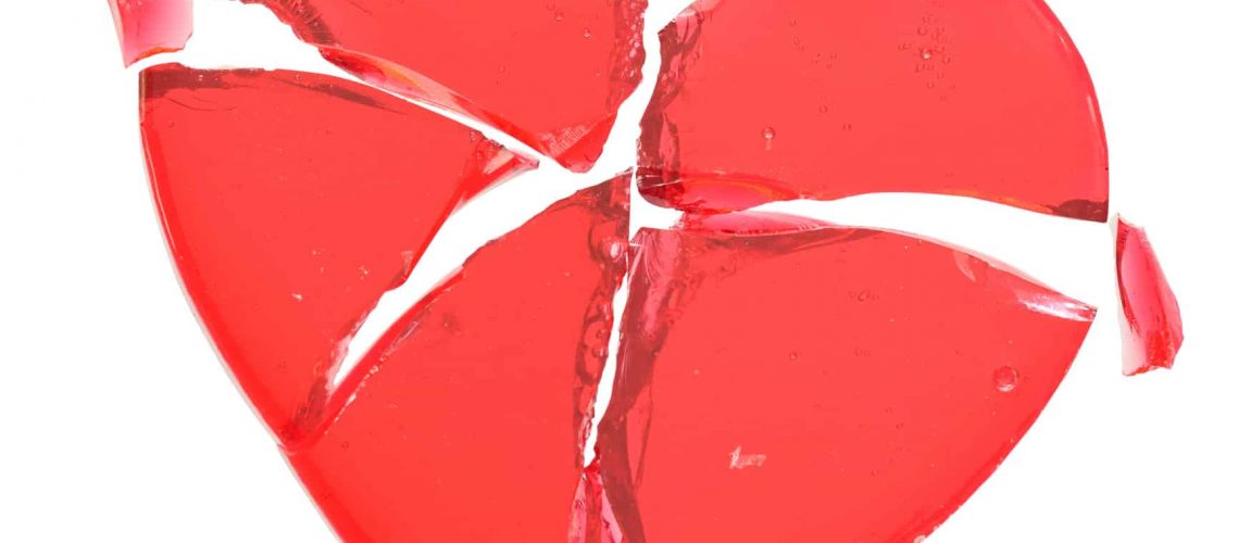 A red caramel lolly broken heart isolated on white