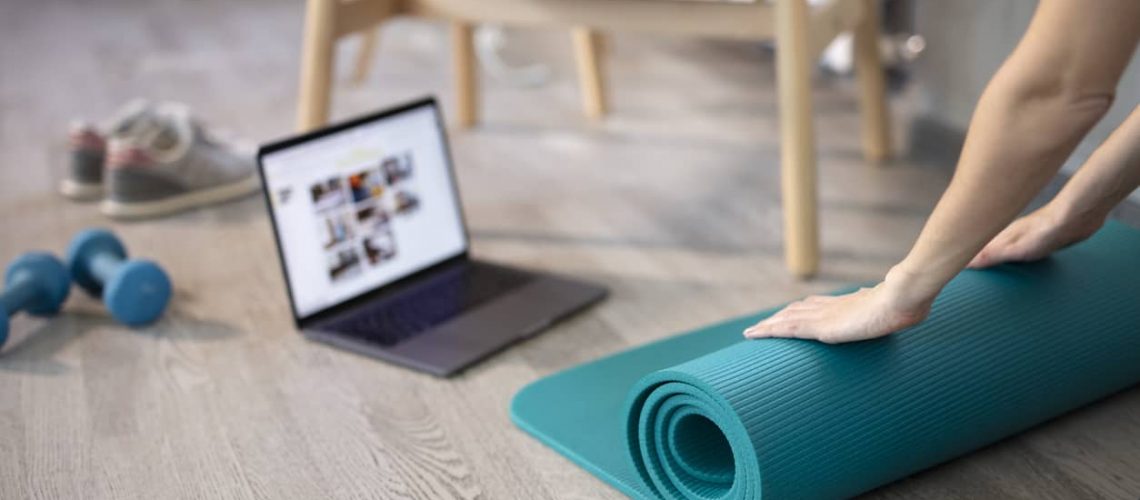 Preparing for training online. Mat, dumbbell, mat and laptop. Preparing for online fitness training at home with laptop and fitness mat. Online training, online fitness, stay home, quarantine, online training.