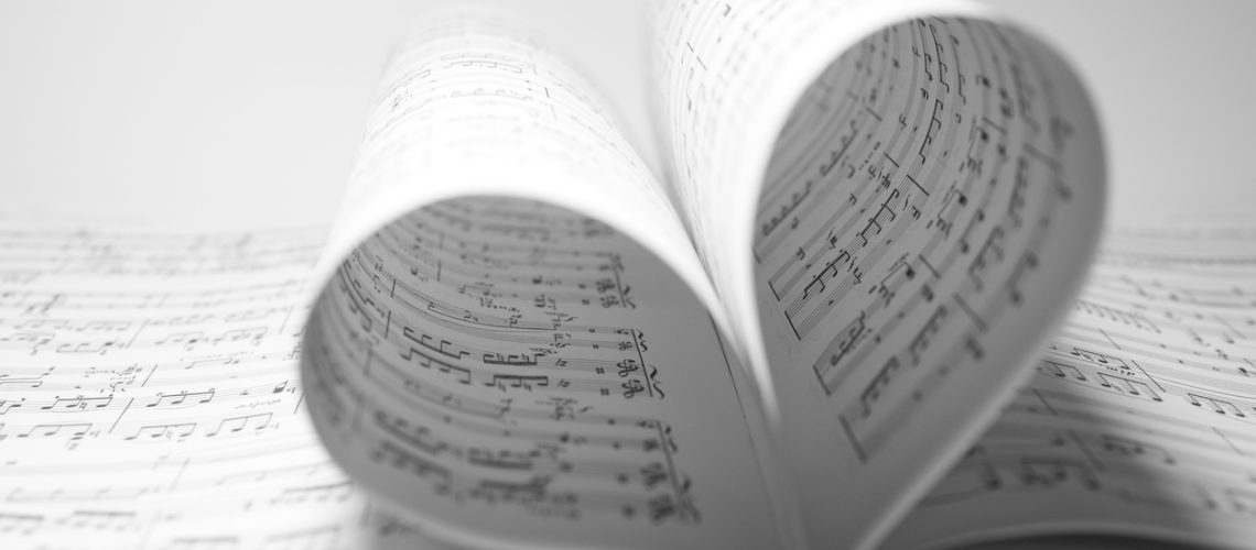 Sheet music bending into a heart shape.