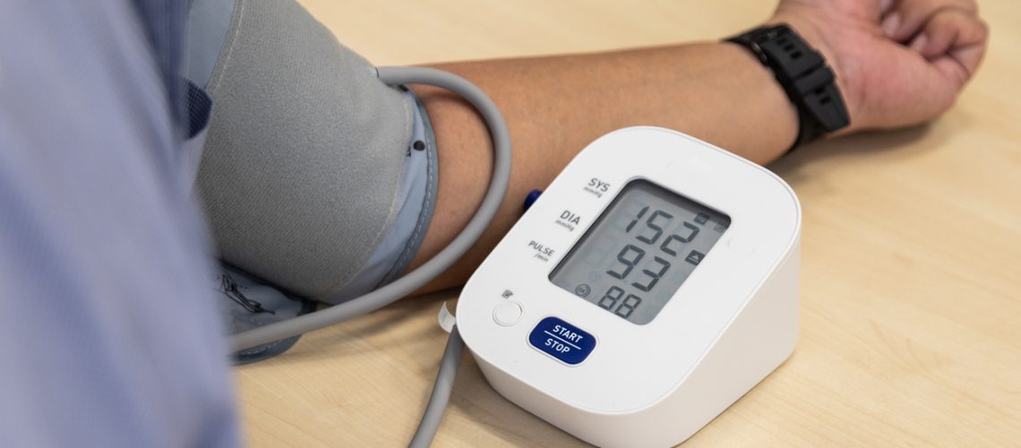 Stressful Asian man blood pressure examination result suggested hypertension with high systolic and diastolic readings