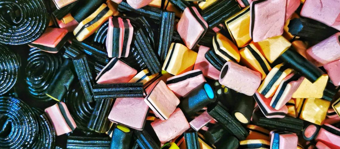 Unique view of a bin of black and mutli colored licorice candies.